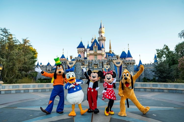 Disneyland characters posing in front of Sleeping Beauty Castle