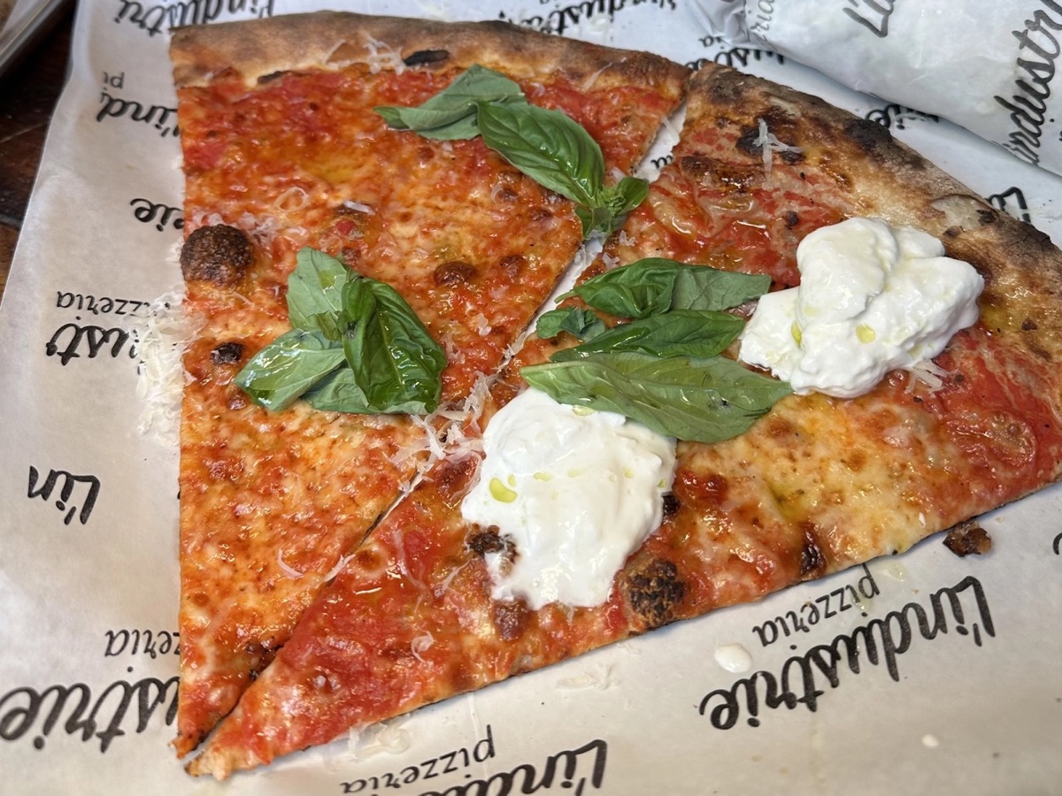 New York-style pizza slices with basil and burrata